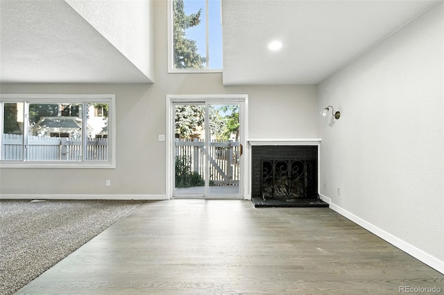 2976 S Parker Ct, Aurora, CO 80014 - unfurnished living room with a fireplace with raised hearth, healthy amount of natural light, and wood finished floors