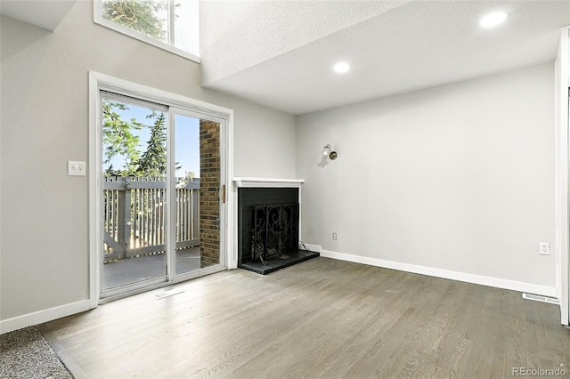 2976 S Parker Ct, Aurora, CO 80014 - unfurnished living room with wood finished floors, a fireplace with raised hearth, and recessed lighting