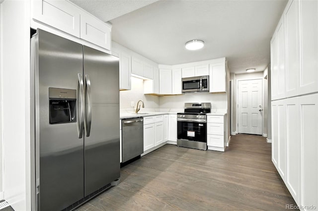 2976 S Parker Ct, Aurora, CO 80014 - kitchen featuring appliances with stainless steel finishes, dark wood-type flooring, light countertops, and white cabinetry
