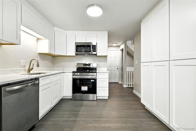 2976 S Parker Ct, Aurora, CO 80014 - kitchen featuring appliances with stainless steel finishes, dark wood finished floors, white cabinetry, and light stone countertops