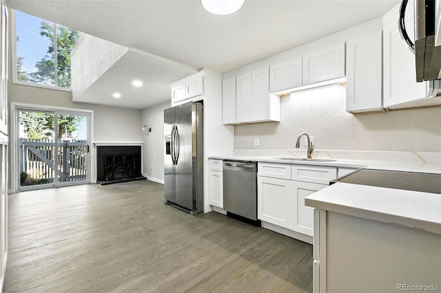 2976 S Parker Ct, Aurora, CO 80014 - kitchen with appliances with stainless steel finishes, wood finished floors, white cabinetry, light countertops, and recessed lighting