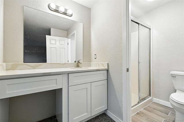 2976 S Parker Ct, Aurora, CO 80014 - bathroom with vanity, a stall shower, a textured wall, and wood finished floors