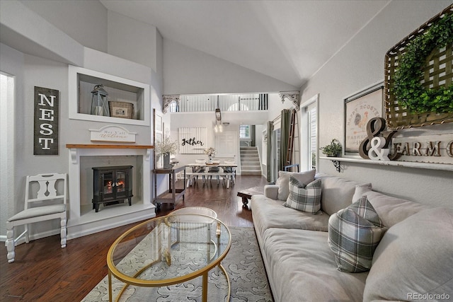 5107 Pasadena Way, Broomfield, CO 80023 - living area with stairway, a lit fireplace, wood finished floors, and high vaulted ceiling