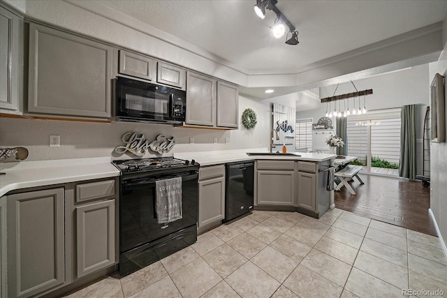 5107 Pasadena Way, Broomfield, CO 80023 - kitchen with black appliances, gray cabinets, a peninsula, light tile patterned floors, and light countertops