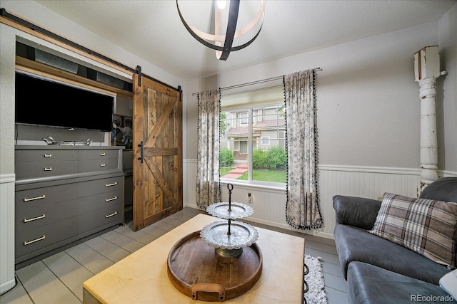 5107 Pasadena Way, Broomfield, CO 80023 - living area featuring a barn door and a wainscoted wall