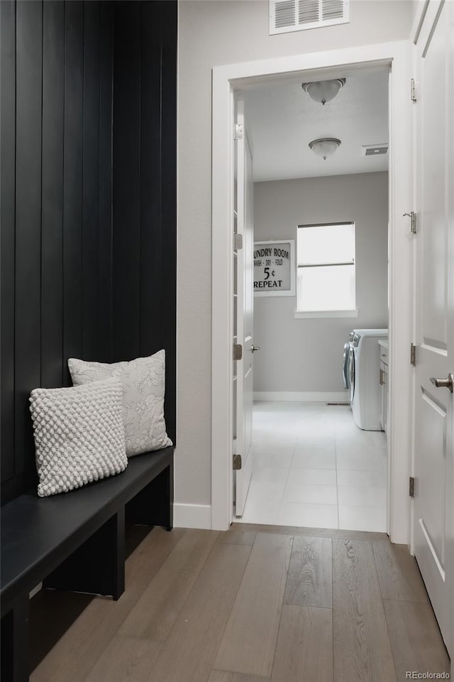 bathroom featuring washing machine and clothes dryer and hardwood / wood-style floors