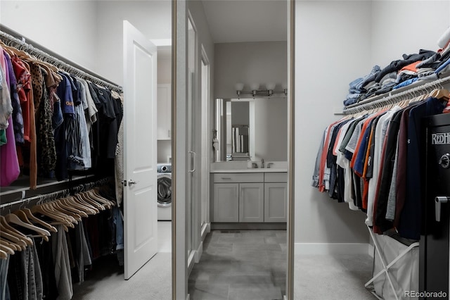 spacious closet featuring washer / dryer and sink