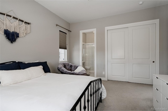 bedroom featuring ensuite bath, a closet, and light carpet