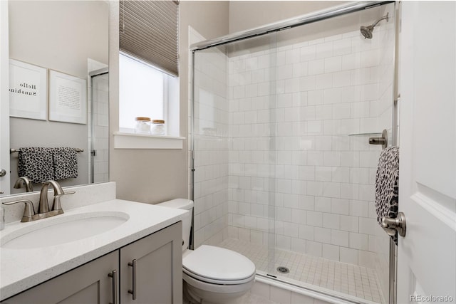 bathroom with vanity, toilet, and tiled shower