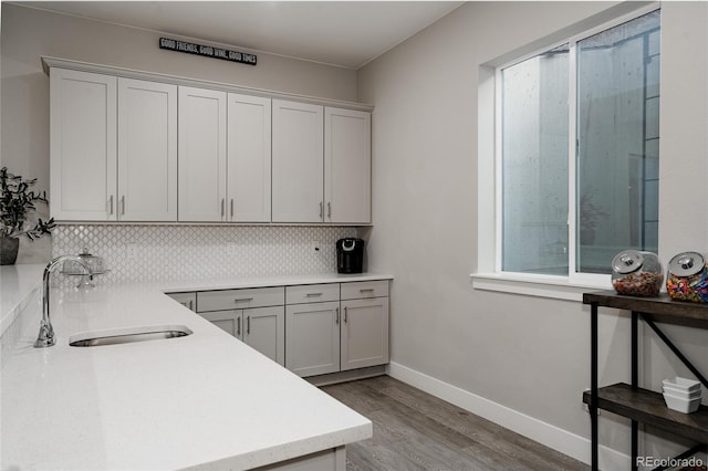 kitchen with sink, light hardwood / wood-style floors, and decorative backsplash