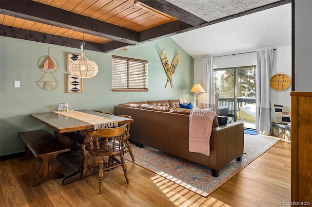 living room featuring beam ceiling, light hardwood / wood-style floors, and wooden ceiling