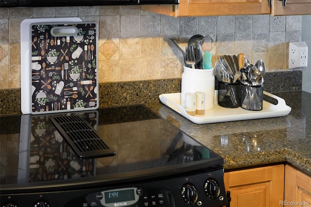 kitchen with dark stone countertops and backsplash