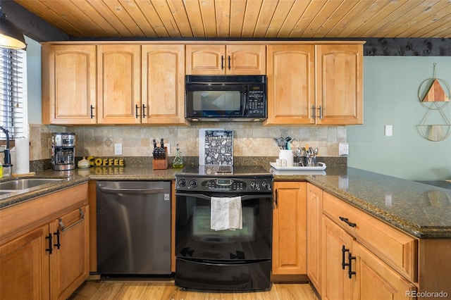 kitchen with dark stone counters, light hardwood / wood-style floors, black appliances, and sink