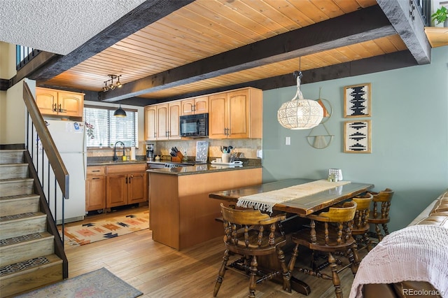 kitchen with pendant lighting, white fridge, light wood-type flooring, beamed ceiling, and sink