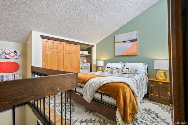 bedroom with a textured ceiling and vaulted ceiling