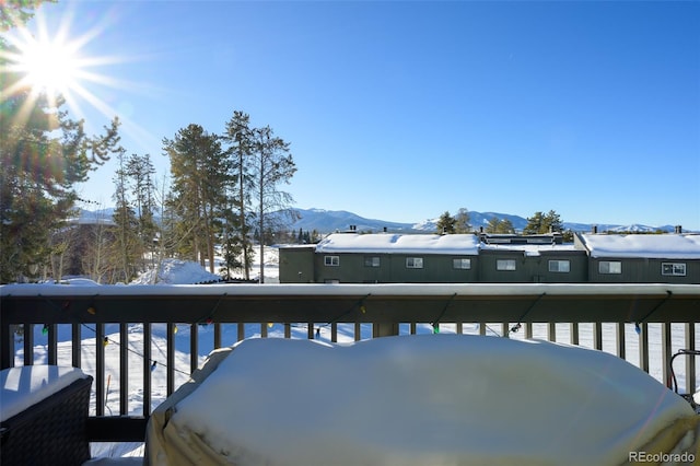 snow covered deck with a mountain view