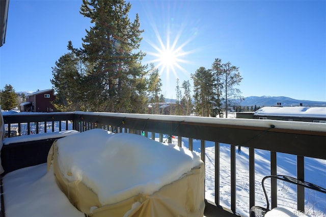 snow covered deck with a mountain view