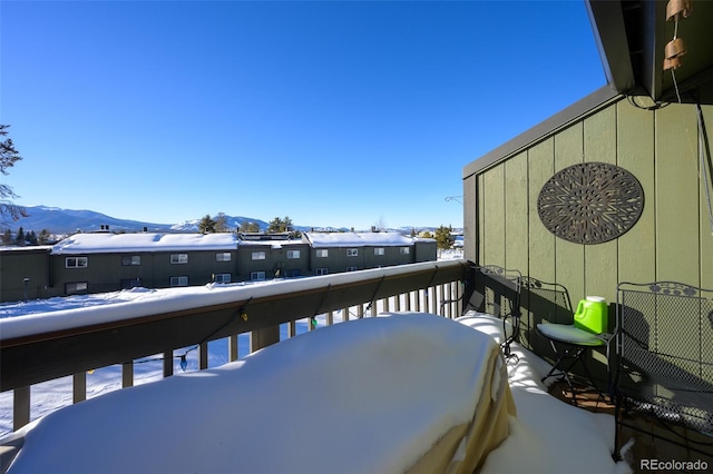 snow covered back of property with a mountain view