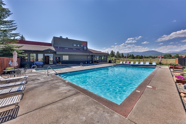 view of pool with a patio area and a mountain view