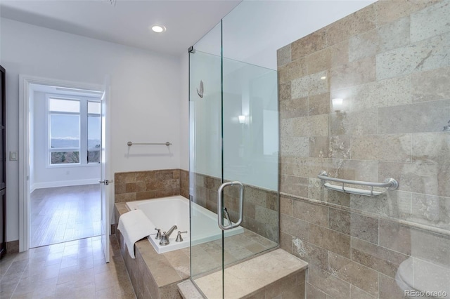 full bathroom featuring a stall shower, baseboards, recessed lighting, and a bath