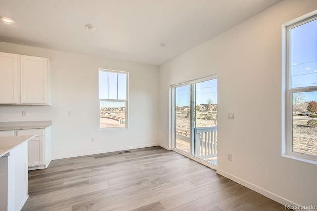 unfurnished dining area with light wood-type flooring