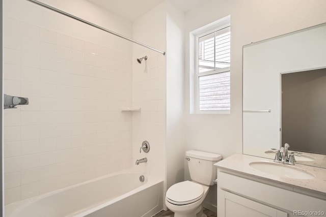 full bathroom with tiled shower / bath, vanity, and toilet