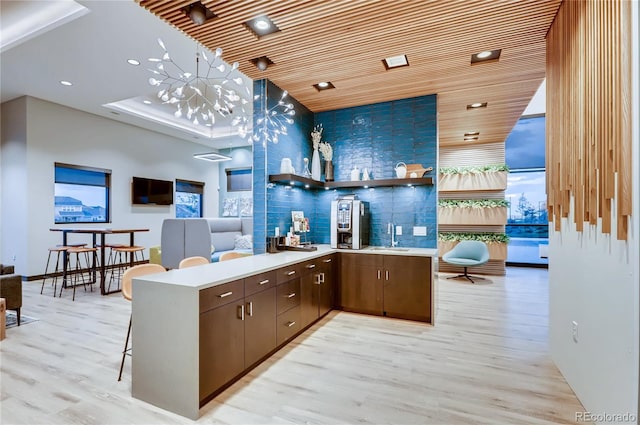 bar with sink, wood ceiling, dark brown cabinets, decorative backsplash, and light wood-type flooring