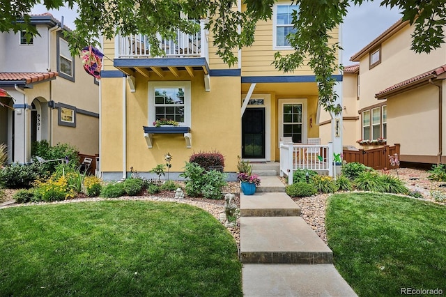 9311 E 5th Ave, Denver, CO 80230 - view of front of property featuring stucco siding, a balcony, and a front yard