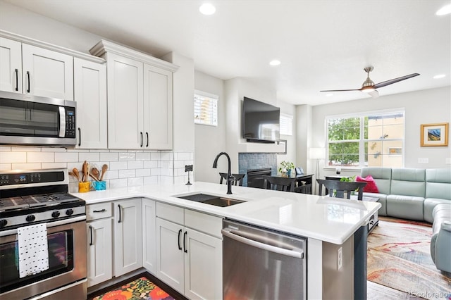 9311 E 5th Ave, Denver, CO 80230 - kitchen featuring stainless steel appliances, open floor plan, a peninsula, light countertops, and tasteful backsplash