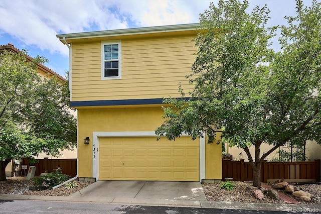 9311 E 5th Ave, Denver, CO 80230 - view of front facade with stucco siding, an attached garage, and concrete driveway