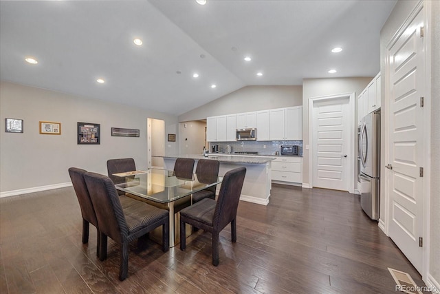 dining area featuring dark hardwood / wood-style floors and vaulted ceiling