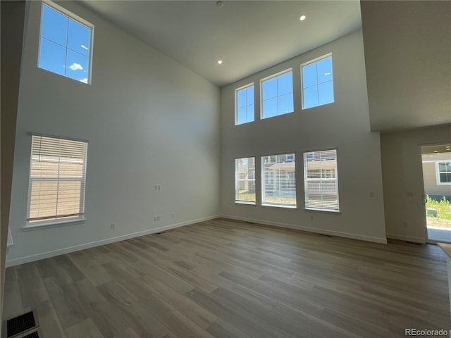 4598 Windmill Dr, Brighton, CO 80601 - spare room featuring a high ceiling, wood finished floors, plenty of natural light, and recessed lighting