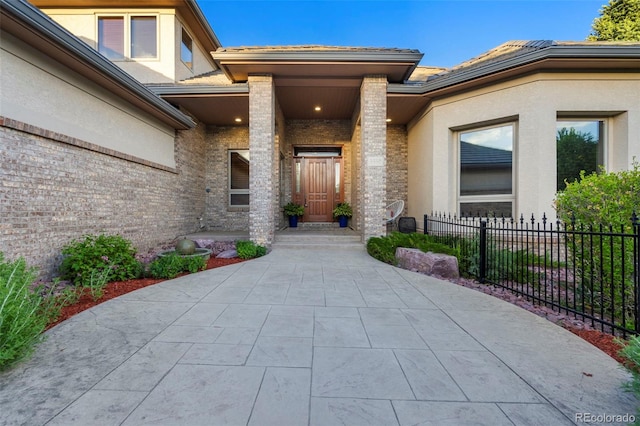 5350 S Marshall St, Littleton, CO 80123 - view of exterior entry featuring stucco siding, a tiled roof, and brick siding
