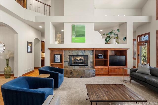 5350 S Marshall St, Littleton, CO 80123 - carpeted living room featuring a high ceiling, arched walkways, and a tiled fireplace