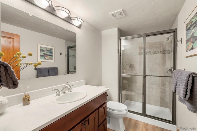 5350 S Marshall St, Littleton, CO 80123 - bathroom with wood finished floors, vanity, toilet, and a stall shower