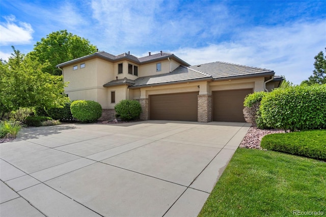 5350 S Marshall St, Littleton, CO 80123 - view of front facade featuring an attached garage, driveway, stucco siding, brick siding, and a tile roof