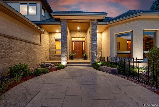 5350 S Marshall St, Littleton, CO 80123 - exterior entry at dusk featuring stucco siding, brick siding, and a tiled roof