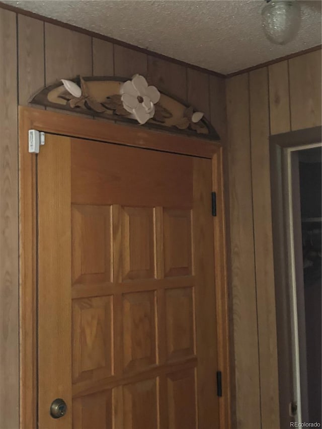 interior details with a textured ceiling and wooden walls