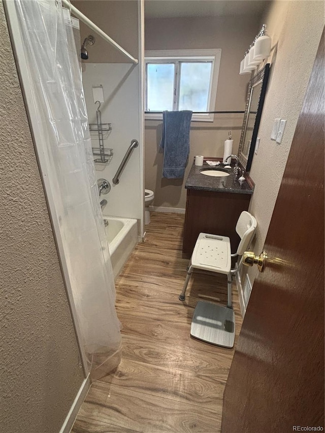 full bath with toilet, vanity, wood finished floors, baseboards, and shower / bath combination with curtain
