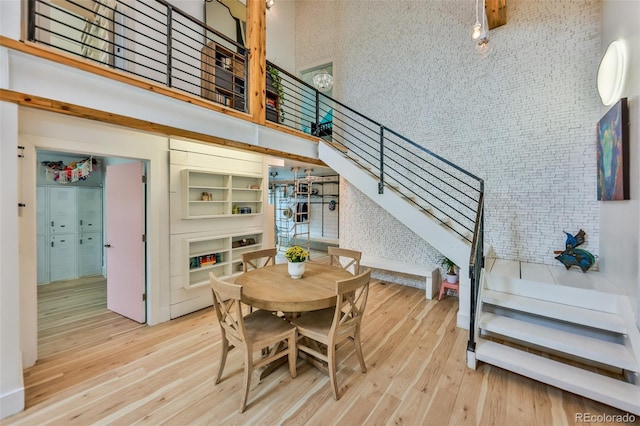 dining room featuring a high ceiling and light hardwood / wood-style flooring