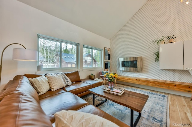 living room featuring light hardwood / wood-style flooring, plenty of natural light, and high vaulted ceiling