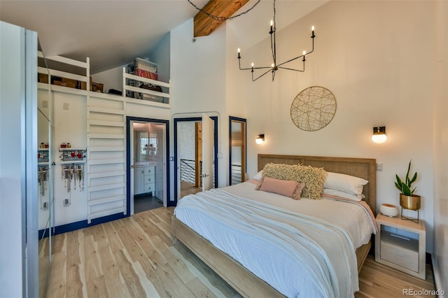 bedroom with wood-type flooring, a notable chandelier, and a high ceiling