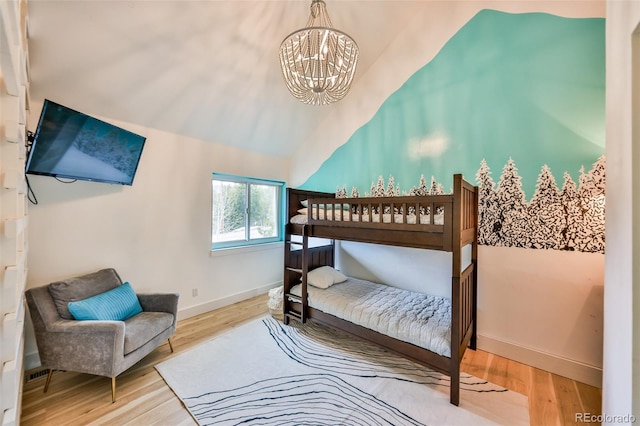 bedroom with vaulted ceiling, a chandelier, and wood-type flooring