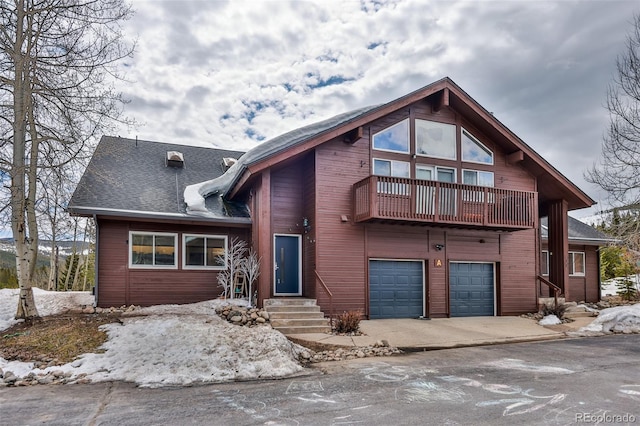 front of property featuring a balcony and a garage