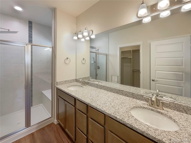 bathroom with a shower with door, vanity, and hardwood / wood-style floors