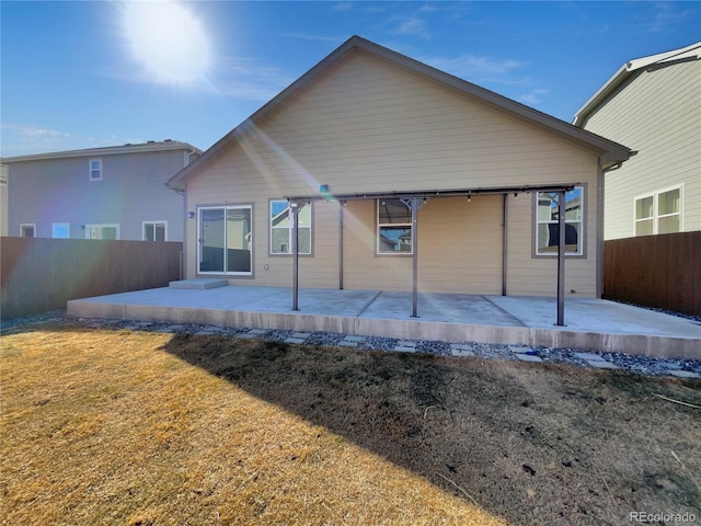 back of house featuring a patio area and a lawn