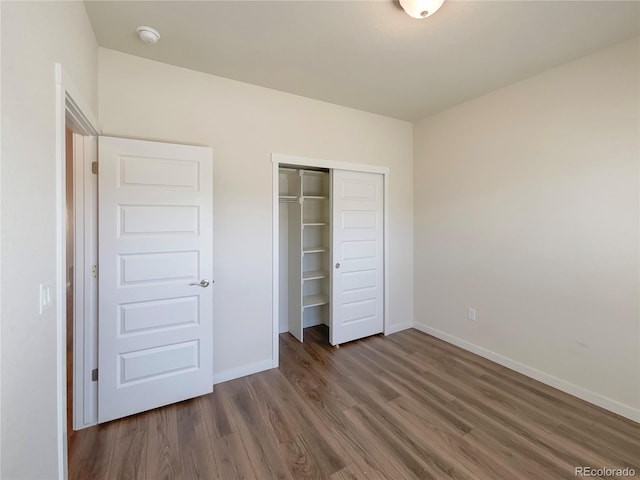 unfurnished bedroom with a closet and dark hardwood / wood-style floors