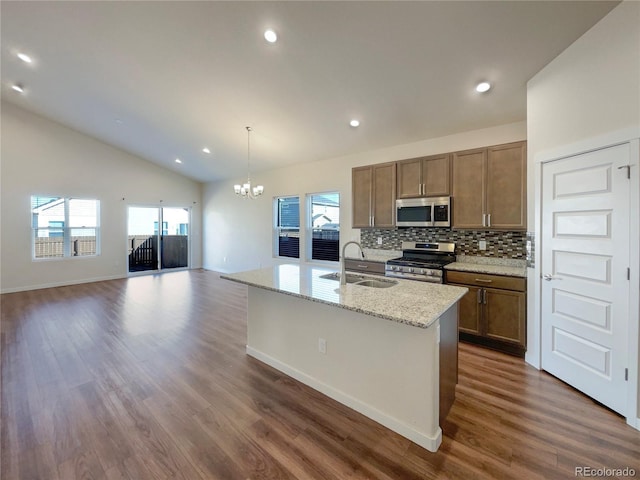 kitchen with stainless steel appliances, a healthy amount of sunlight, sink, and a kitchen island with sink