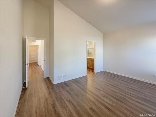 empty room with dark hardwood / wood-style floors and high vaulted ceiling