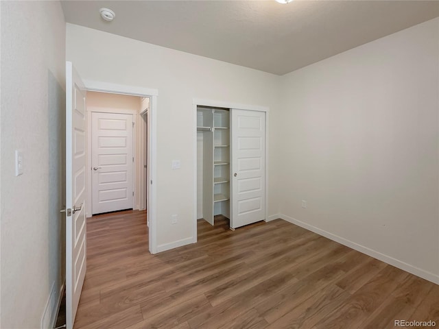 unfurnished bedroom with hardwood / wood-style floors and a closet